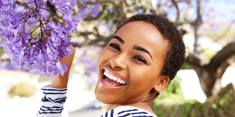 beautiful lady enjoying the smell of purple flowers in spring